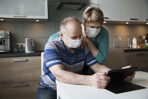 Seniors wearing masks on Facetime in kitchen