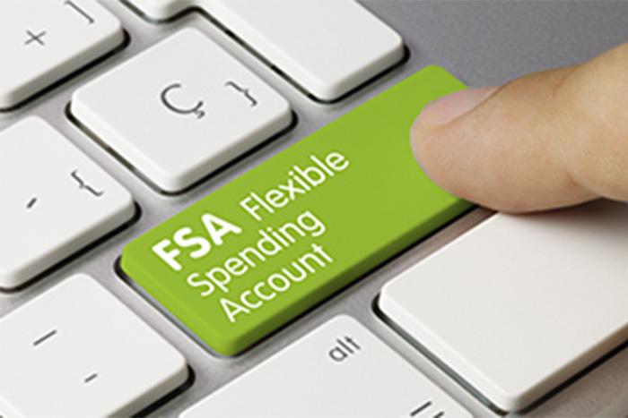 Person click a green button on a keyboard that says "FSA Flexible Spending Account"