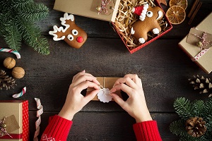 Image of person wrapping a holiday gift of hearing accessories.