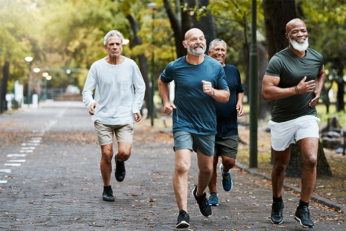 Group of senior men running through a park together for exercise
